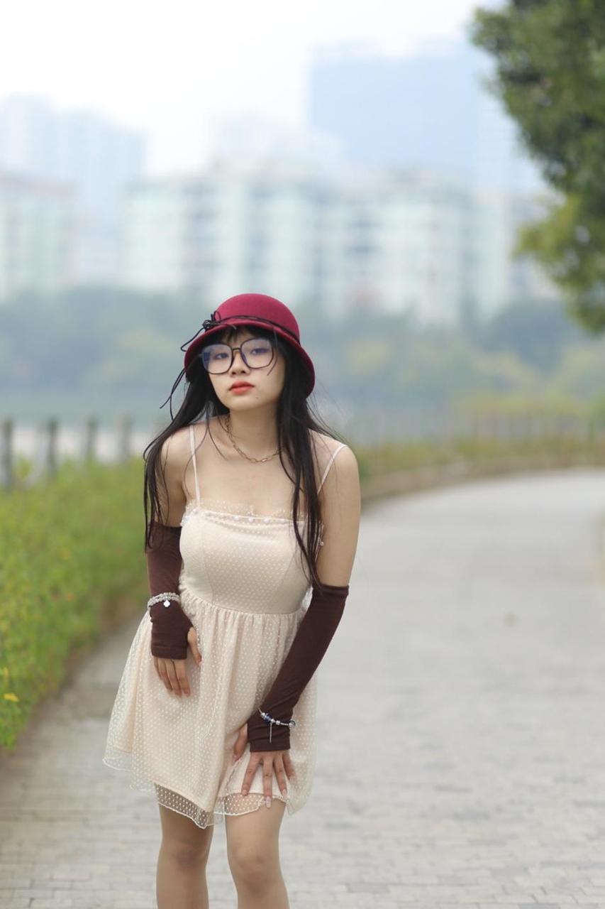 20P Pequena garota asiática com óculos e chapéu posando em seu vestido sexy de verão lá fora