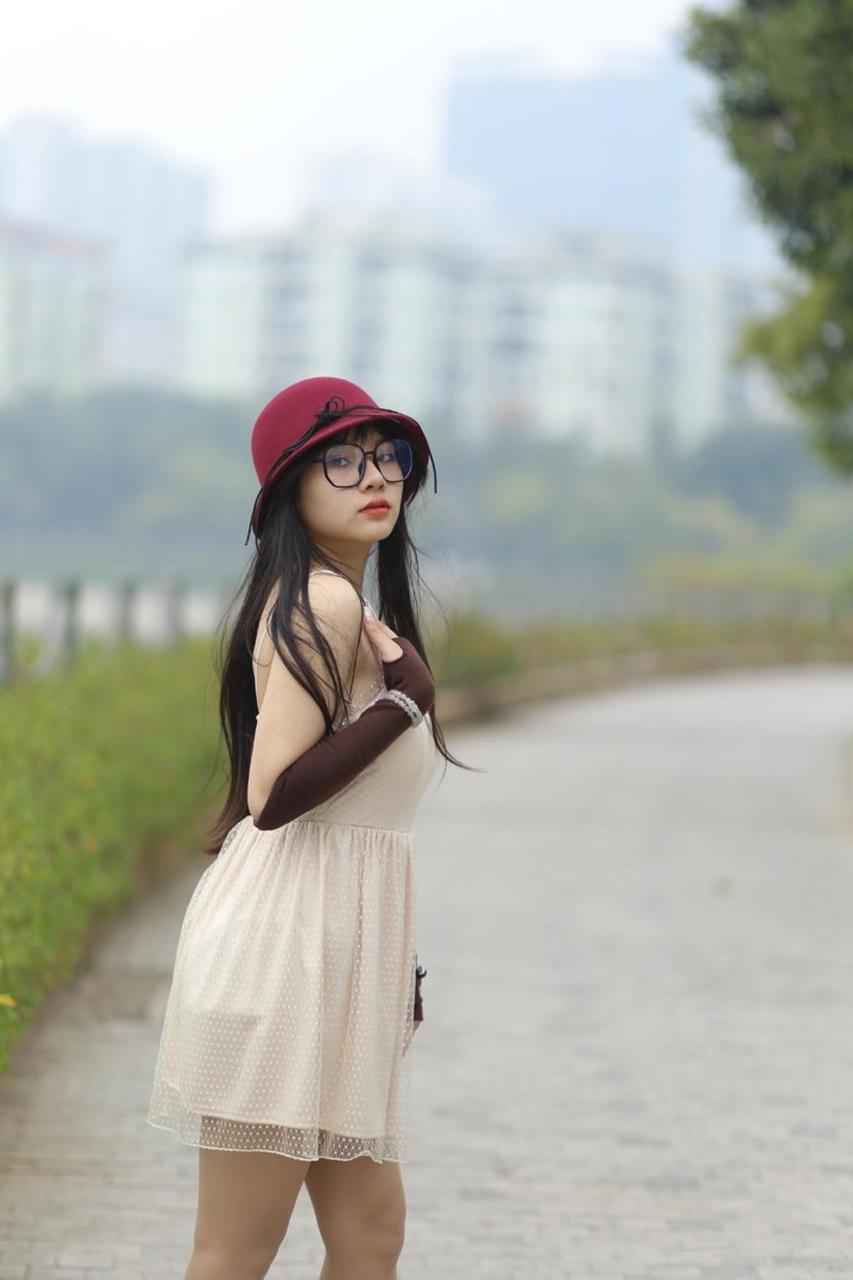 20P Pequena garota asiática com óculos e chapéu posando em seu vestido sexy de verão lá fora