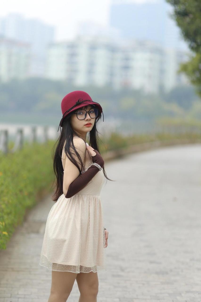 20P Pequena garota asiática com óculos e chapéu posando em seu vestido sexy de verão lá fora