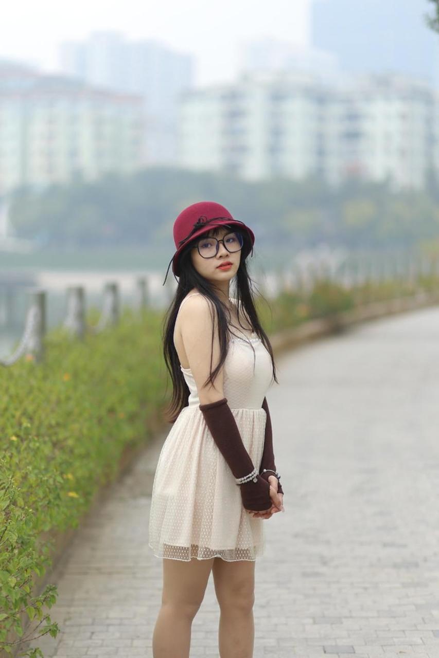 20P Pequena garota asiática com óculos e chapéu posando em seu vestido sexy de verão lá fora