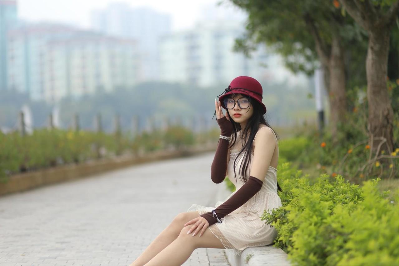 20P Pequena garota asiática com óculos e chapéu posando em seu vestido sexy de verão lá fora