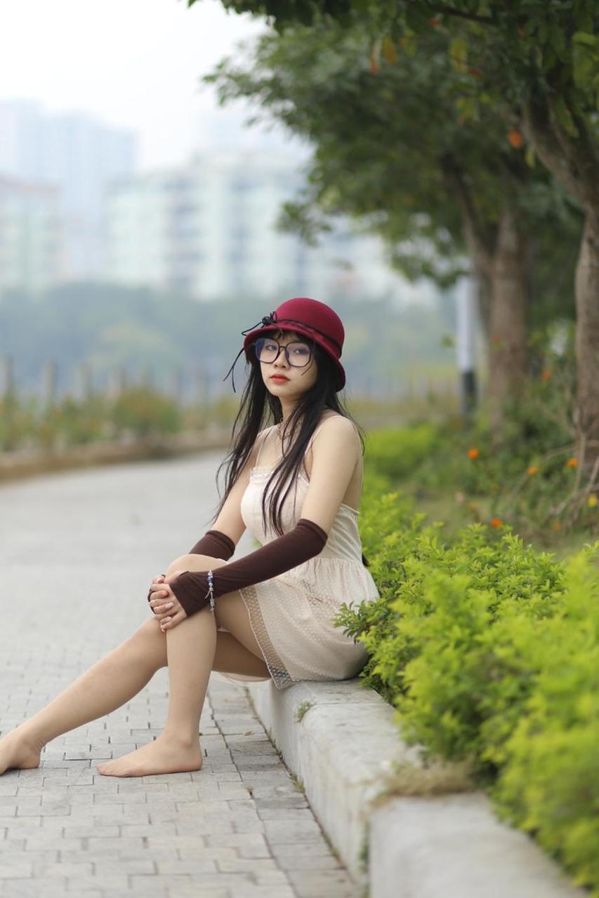 20P Pequena garota asiática com óculos e chapéu posando em seu vestido sexy de verão lá fora