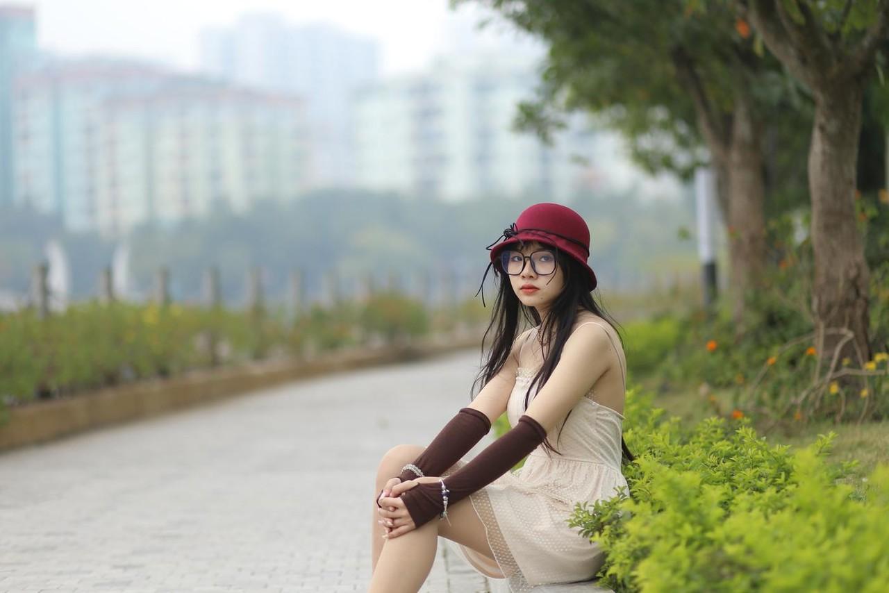 20P Pequena garota asiática com óculos e chapéu posando em seu vestido sexy de verão lá fora