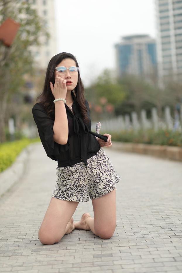 20P Nena asiática descalza hace alarde de sus piernas sexys al aire libre con una minifalda