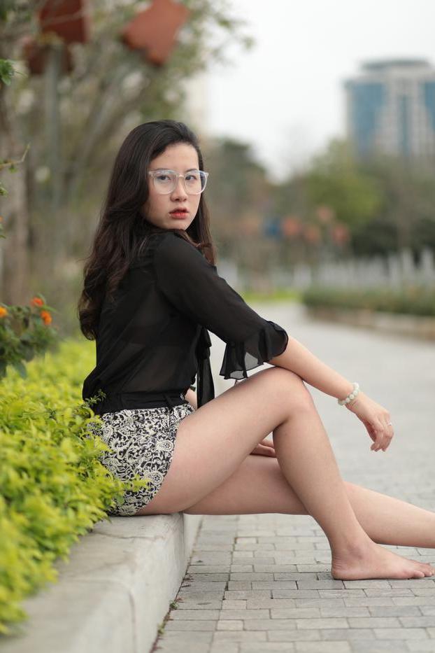 20P Nena asiática descalza hace alarde de sus piernas sexys al aire libre con una minifalda