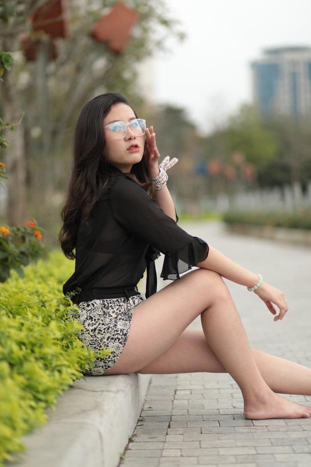 20P Nena asiática descalza hace alarde de sus piernas sexys al aire libre con una minifalda