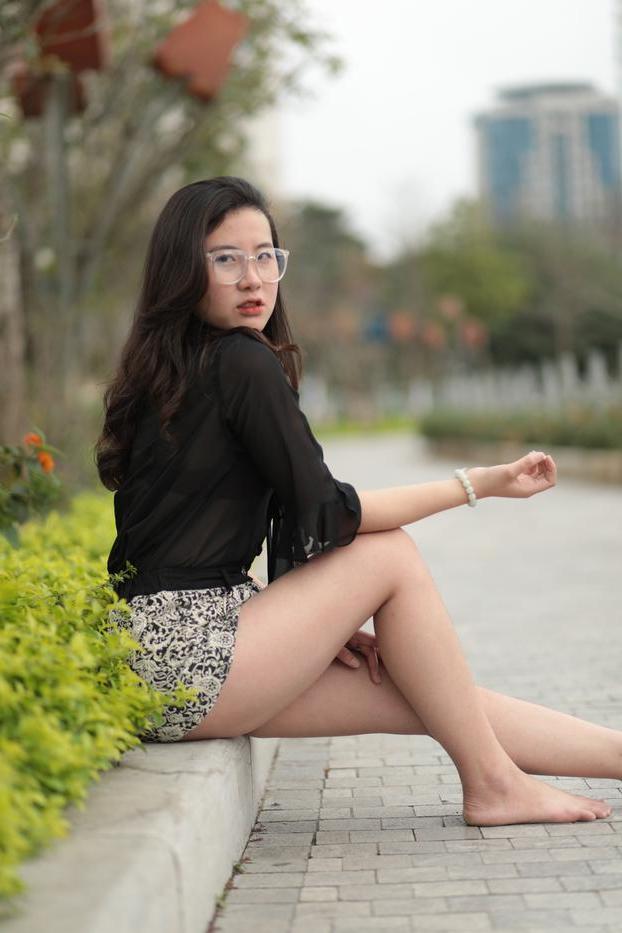 20P Nena asiática descalza hace alarde de sus piernas sexys al aire libre con una minifalda