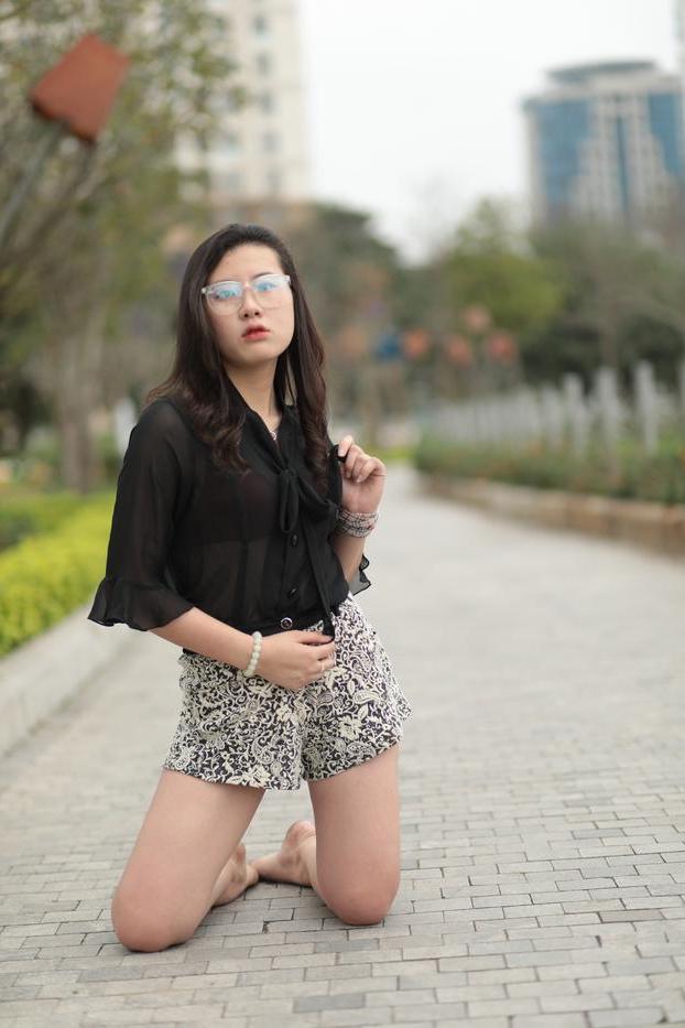 20P Nena asiática descalza hace alarde de sus piernas sexys al aire libre con una minifalda