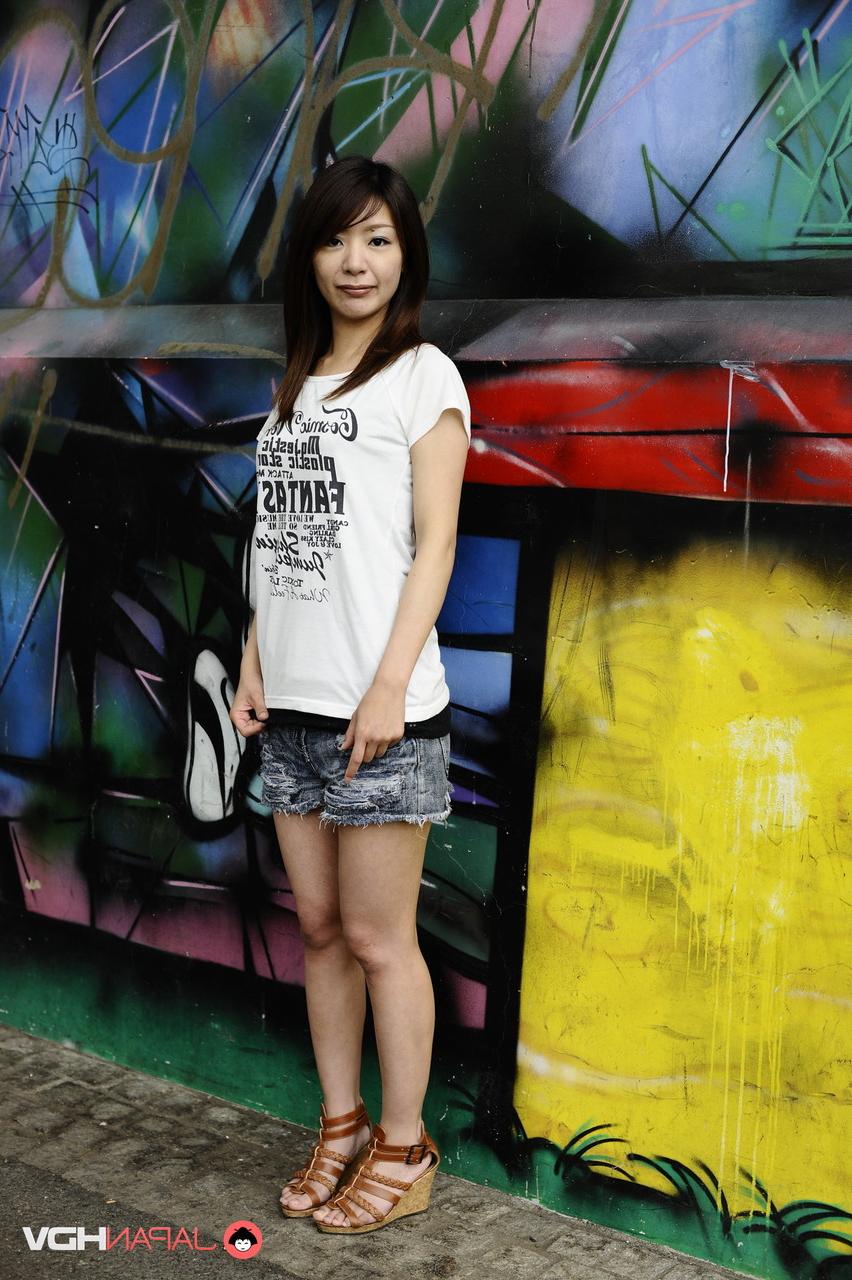 15P Das japanische Solo-Mädchen Tomomi Matsuda posiert im Freien in einem T-Shirt und Jeansshorts