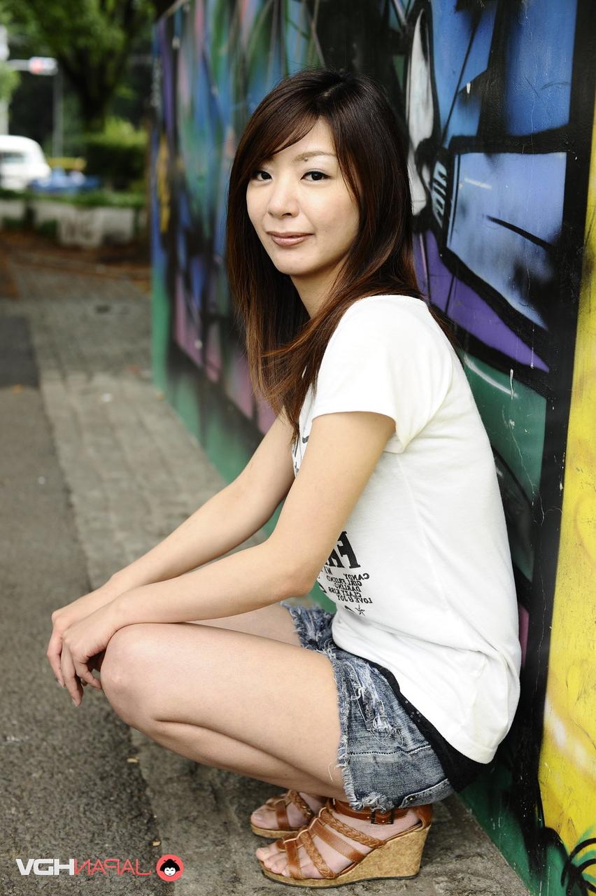 15P Das japanische Solo-Mädchen Tomomi Matsuda posiert im Freien in einem T-Shirt und Jeansshorts