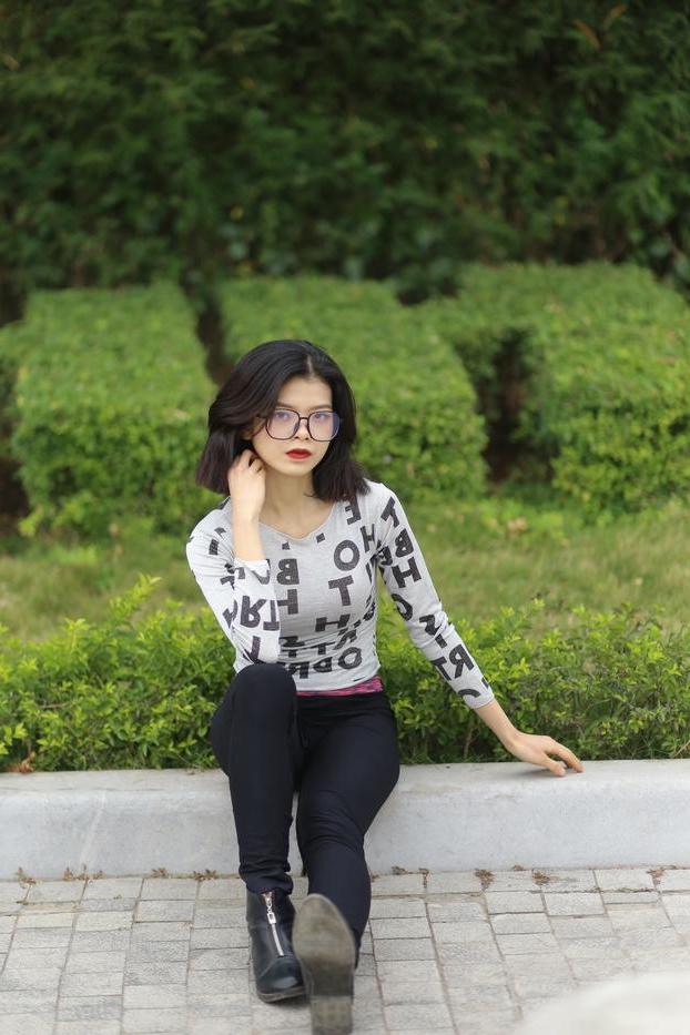 20P Pequena menina asiática com óculos posando de camisa branca e leggings quentes
