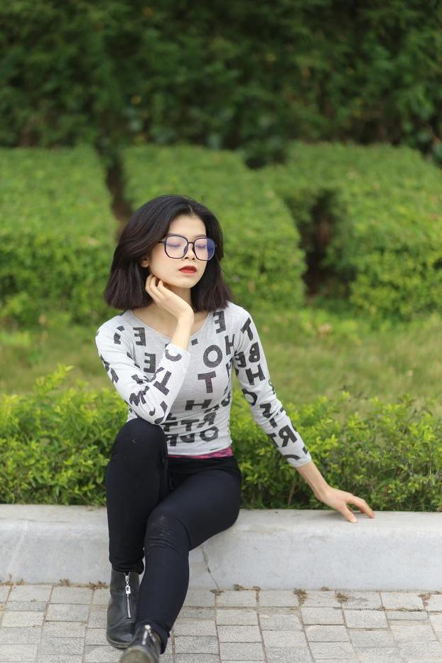 20P Pequena menina asiática com óculos posando de camisa branca e leggings quentes