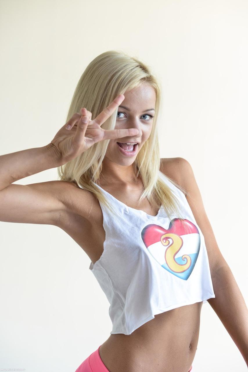 20P A adolescente magrinha Sissie posando com sua camisa sexy e leggings rosa em um solo
