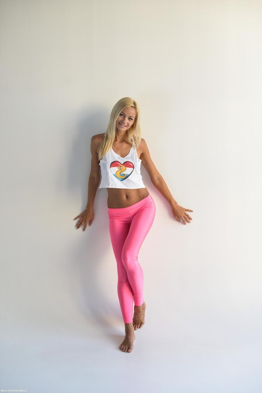 20P A adolescente magrinha Sissie posando com sua camisa sexy e leggings rosa em um solo