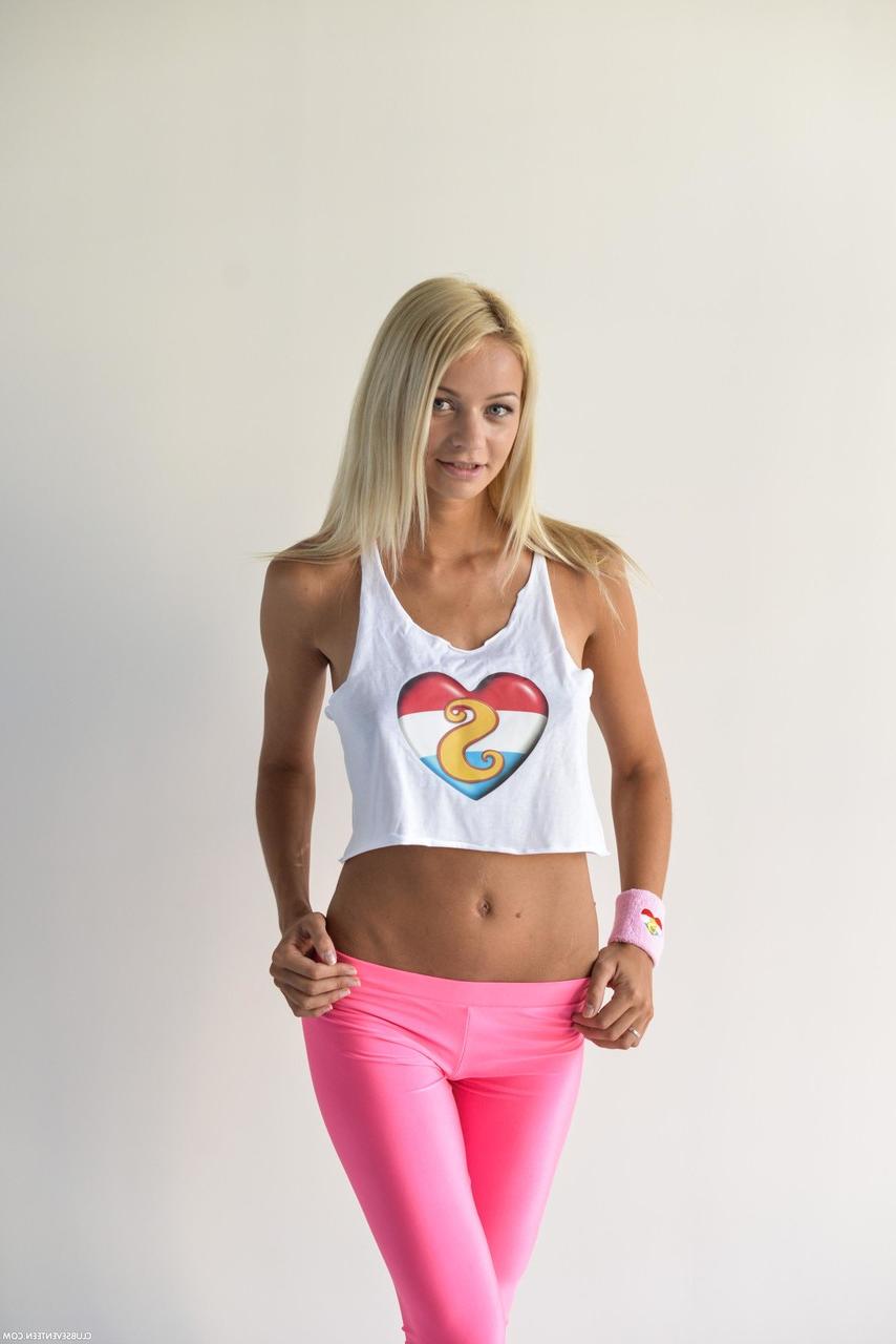 20P A adolescente magrinha Sissie posando com sua camisa sexy e leggings rosa em um solo