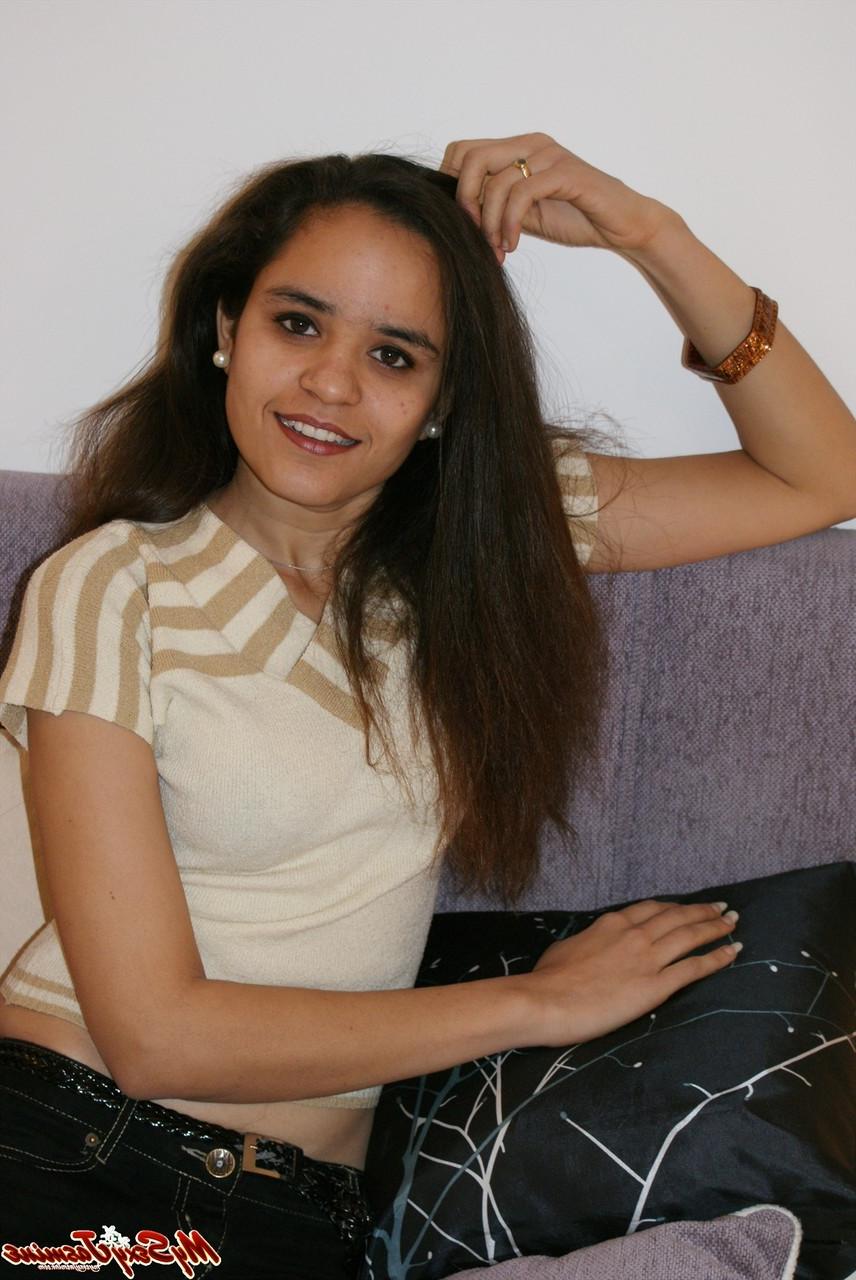 12P La jolie indienne Jasmine Mathur découvre ses petits seins au sommet d'un lit.
