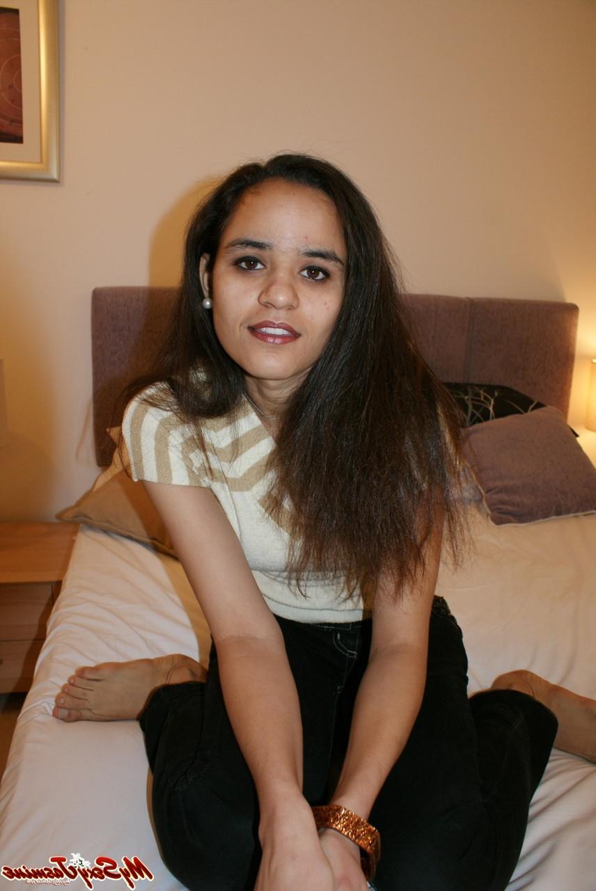 12P La jolie indienne Jasmine Mathur découvre ses petits seins au sommet d'un lit.