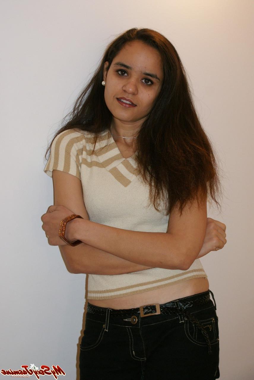 12P La jolie indienne Jasmine Mathur découvre ses petits seins au sommet d'un lit.
