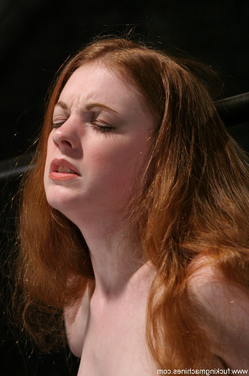 20P La rousse nue Nicole Scott chevauche un gode machine en position debout.