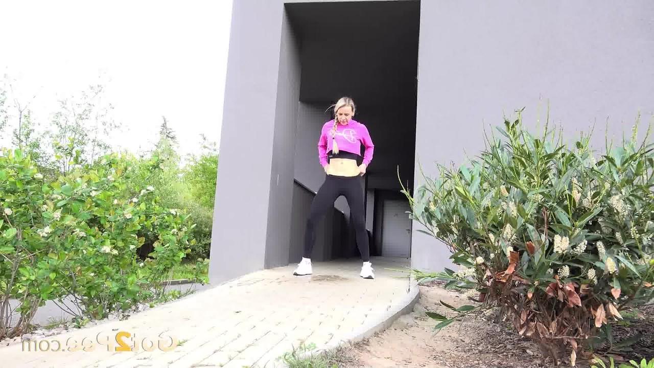 13P A garota loira Bianca puxa leggings pretas para mijar em uma passarela