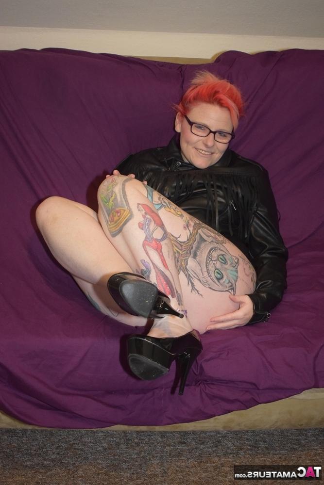 20P Pelirroja tatuada se quita la ropa de cuero para modelar en lencería sexy