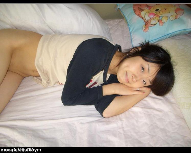 13P Petite copine asiatique montre sa chatte rasée alors qu'elle est allongée nue sur le lit