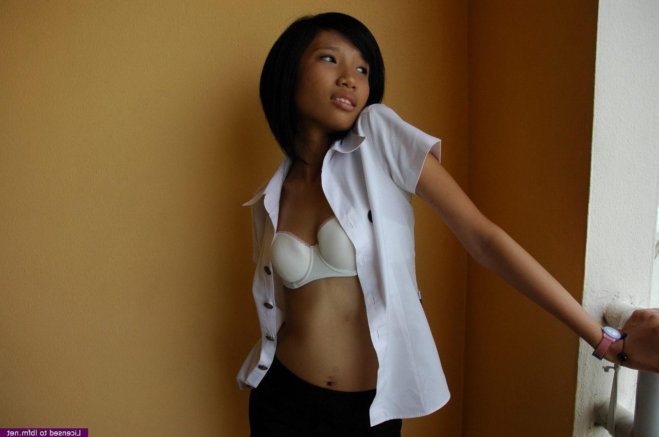 12P Zierlicher asiatischer Teenager zieht einen süßen Tanga aus, bevor er auf einem Bett seine haarige Möse öffnet