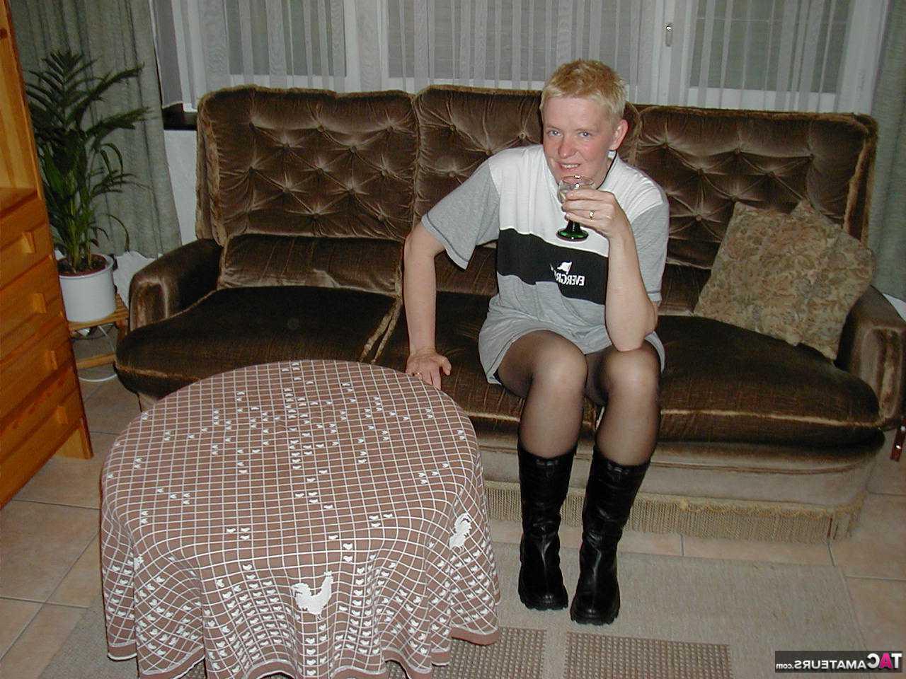 16P La blonde mature Tiffany Pearl se déshabille sur un canapé en bas et bottes noires.