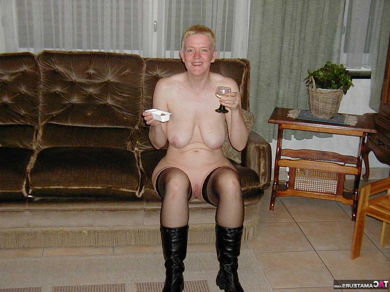 16P La blonde mature Tiffany Pearl se déshabille sur un canapé en bas et bottes noires.