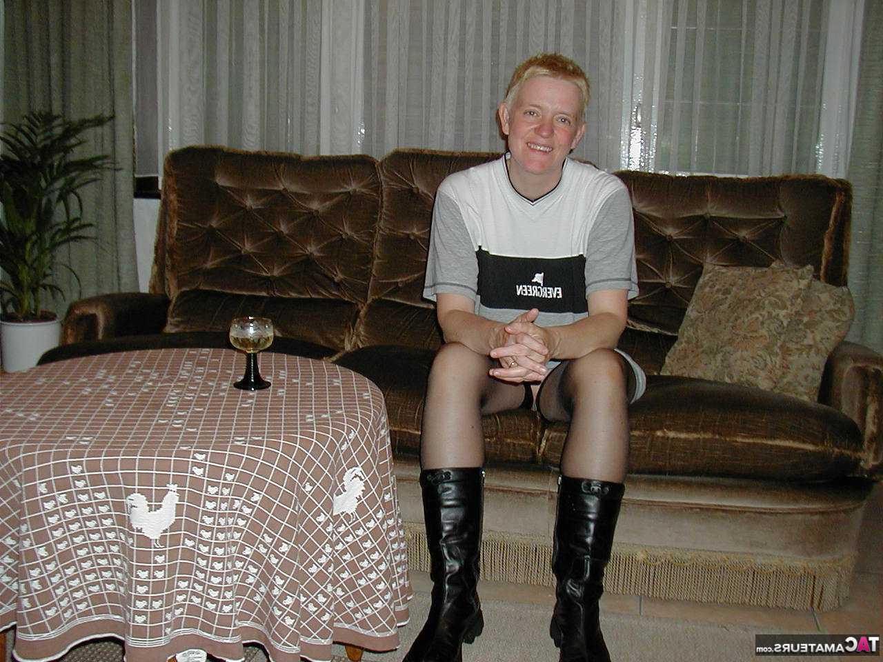 16P La blonde mature Tiffany Pearl se déshabille sur un canapé en bas et bottes noires.