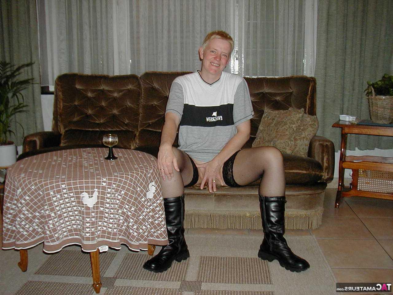 16P La blonde mature Tiffany Pearl se déshabille sur un canapé en bas et bottes noires.