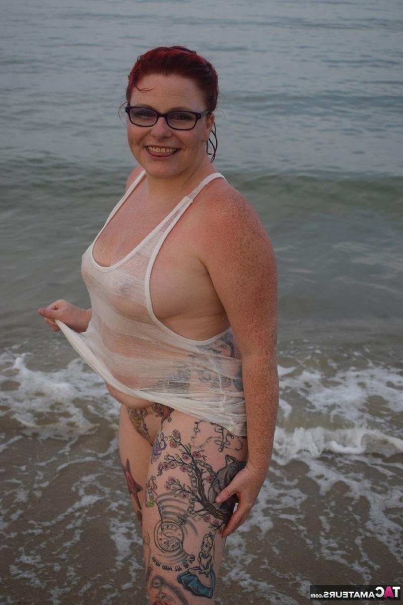 16P Pelirroja tatuada posa desnuda en la playa antes de masturbarse en el asiento del baño