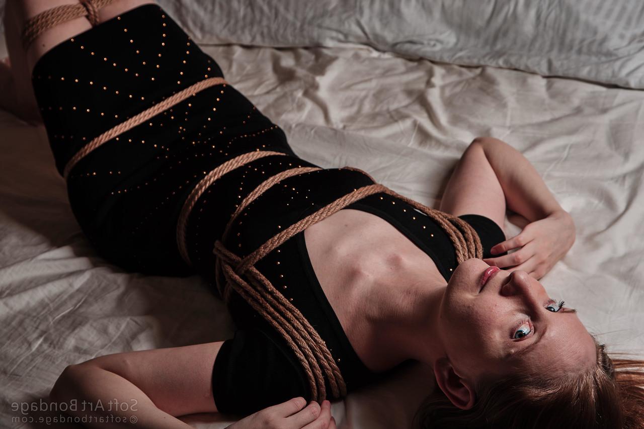 16P Barefoot and clothed female is left tied up in rope upon her bed