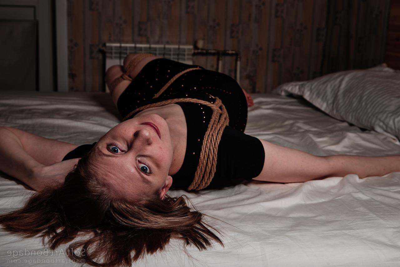 16P Barefoot and clothed female is left tied up in rope upon her bed