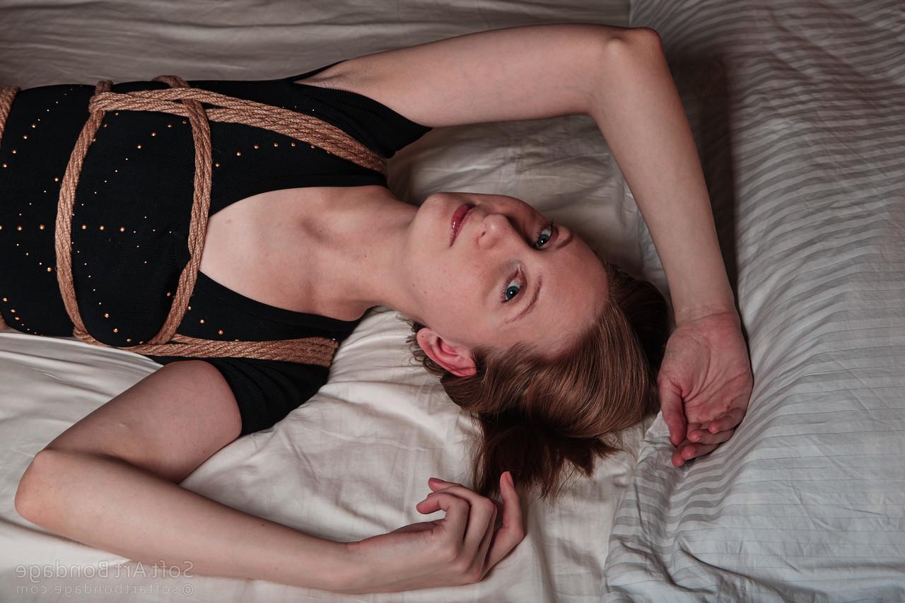 16P Barefoot and clothed female is left tied up in rope upon her bed