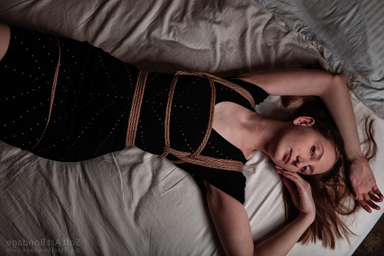 16P Barefoot and clothed female is left tied up in rope upon her bed
