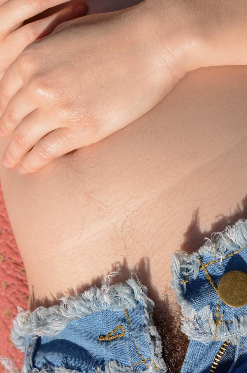 20P Eleanor Rose, rousse aux gros seins, exhibe sa chatte très poilue de près.