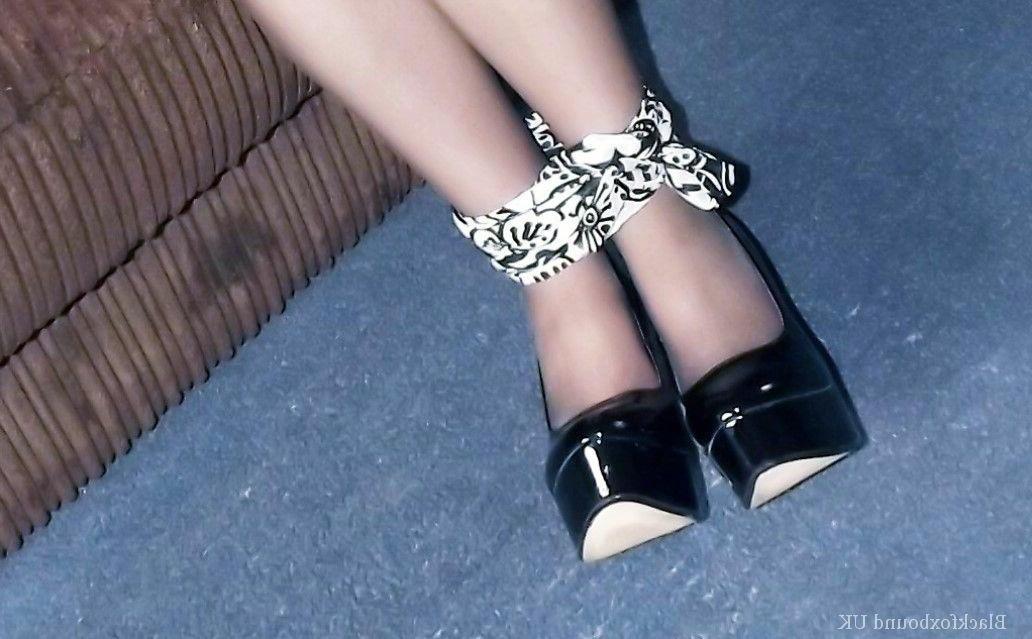 16P La chica vestida Tamara está atada por las muñecas y los tobillos mientras está en un sofá.