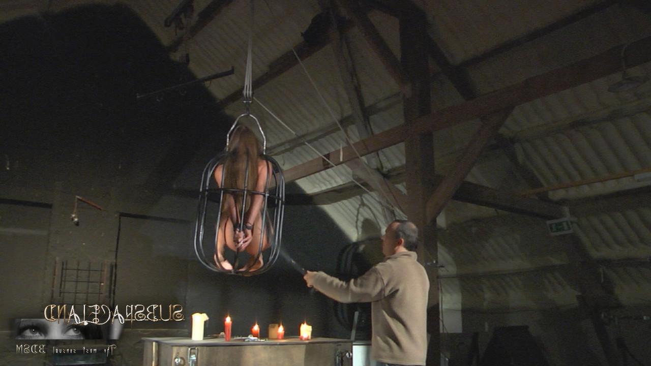20P Cathy Heaven, petite amoureuse du BDSM dans une cage, se fait recouvrir de cire chaude.