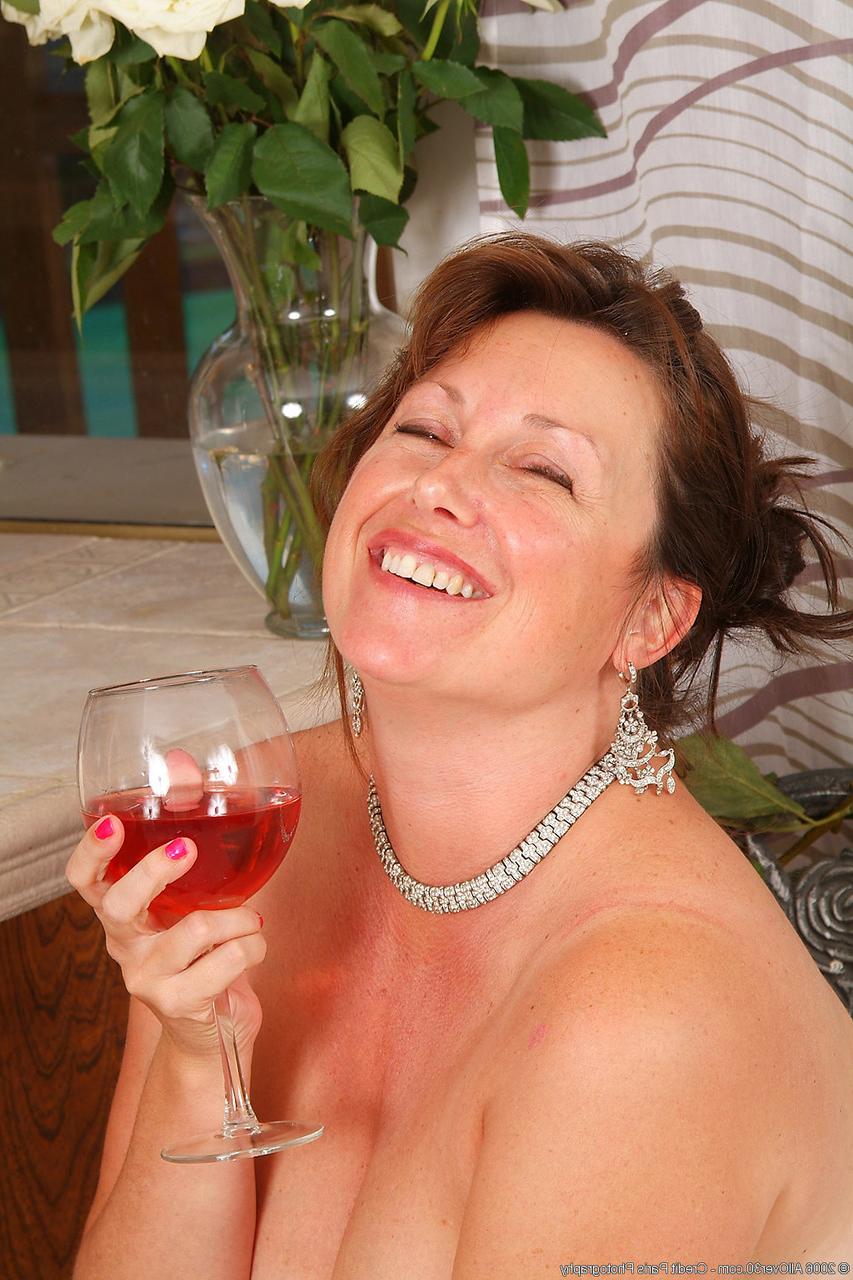 20P A adorável senhora madura Marishka tira e posa enquanto toma uma grande taça de vinho
