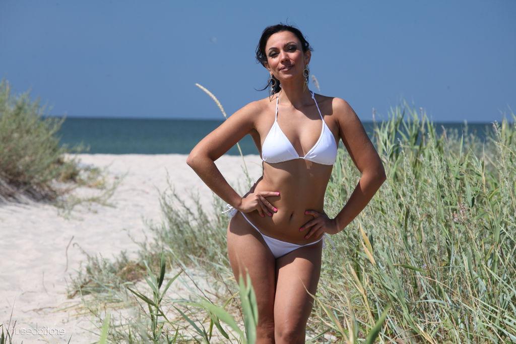 16P Gorgeous brunette Lusee takes off a bikini to get naked at the beach