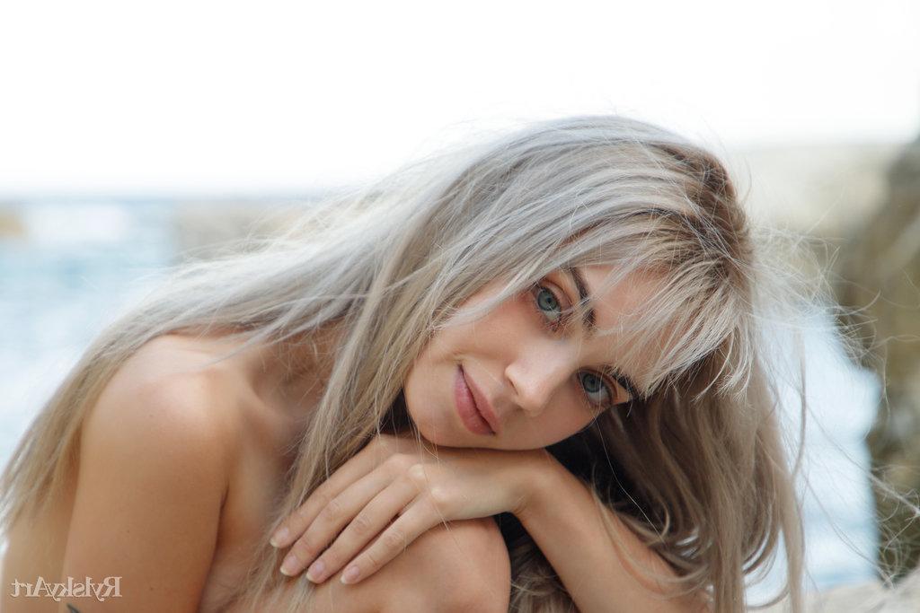 16P La joven rubia platino Sofy Bee posa totalmente desnuda sobre las rocas junto al mar