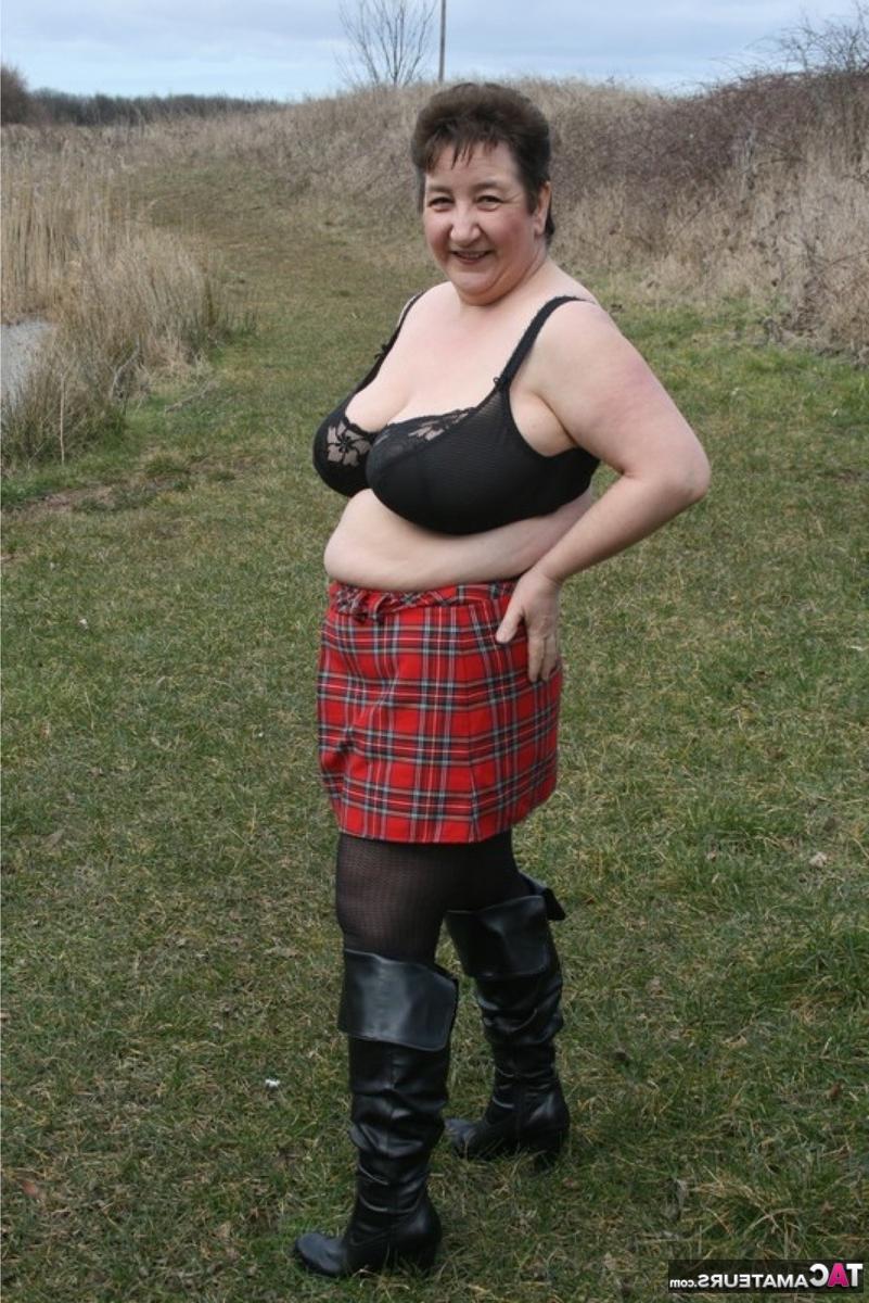 16P La gorda británica Kinky Carol se quita la camisa cerca del agua con una falda a cuadros
