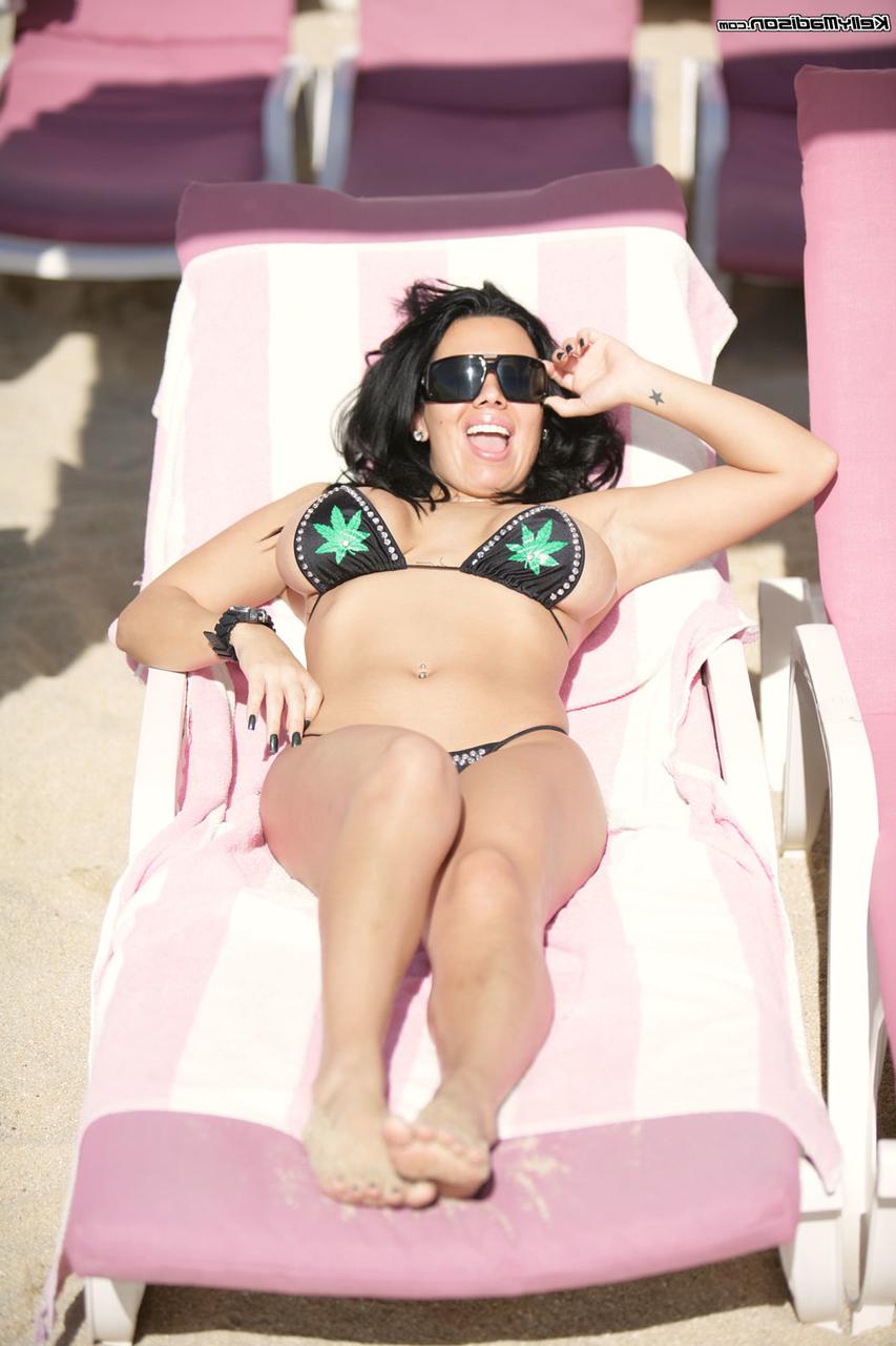 17P A estrela pornográfica de cabelos escuros Sienna West posando na praia e mostrando os peitos