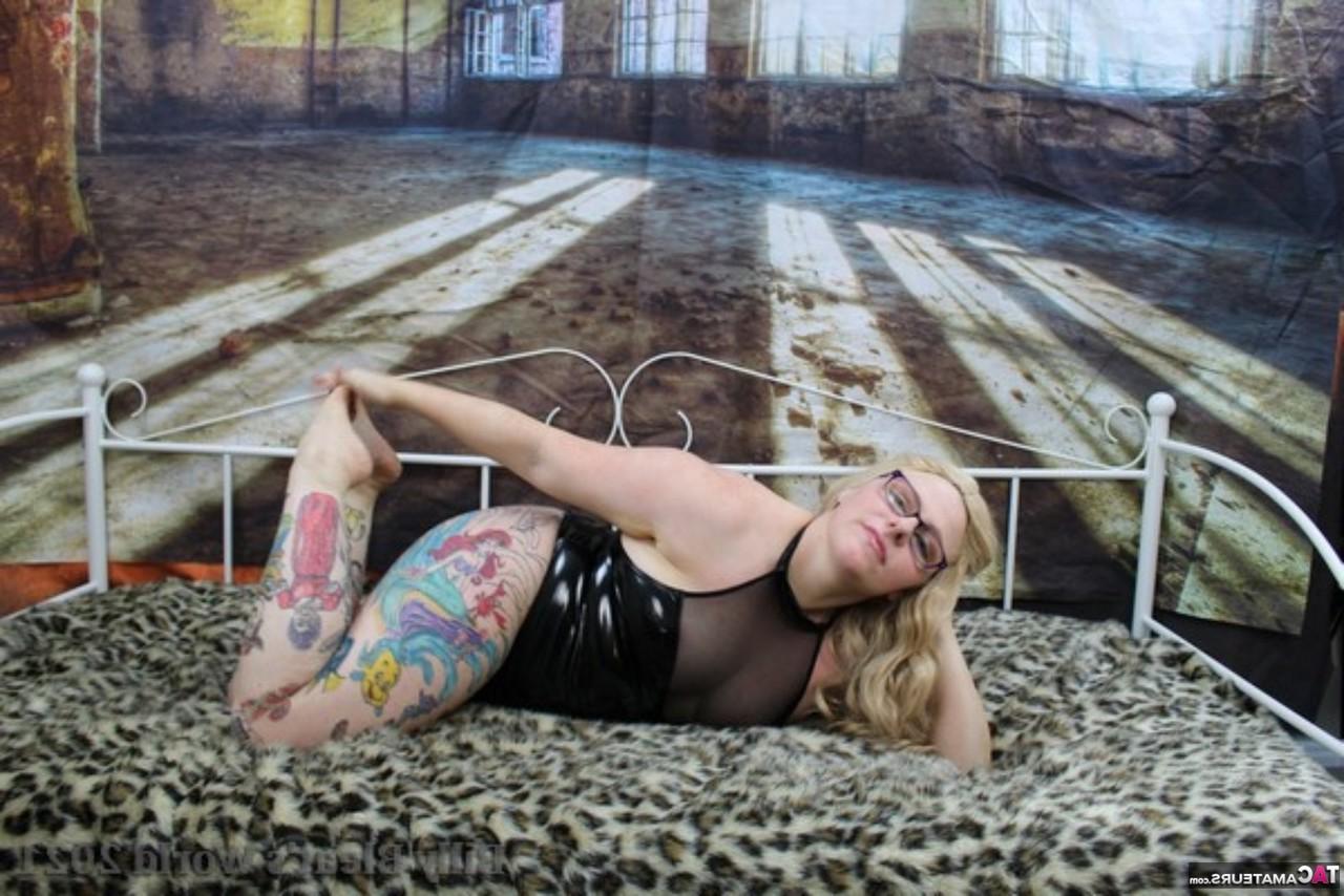 15P La pompeuse britannique tatouée Mollie Foxxx montre ses seins naturels sur un lit de repos.