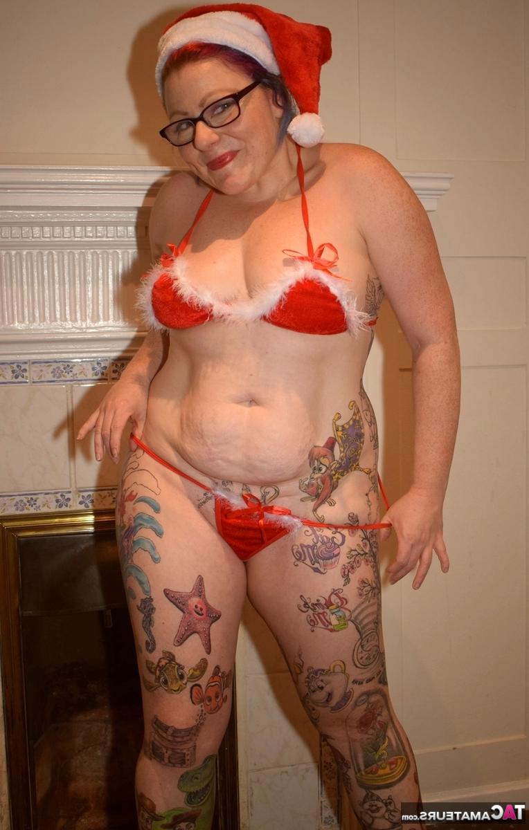 16P Mulher mais velha tatuada descarta pose de biquíni nua com boné de Papai Noel