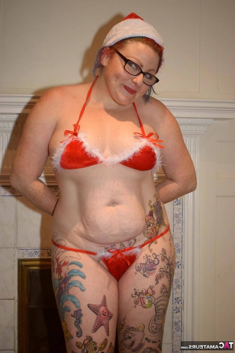 16P Mulher mais velha tatuada descarta pose de biquíni nua com boné de Papai Noel