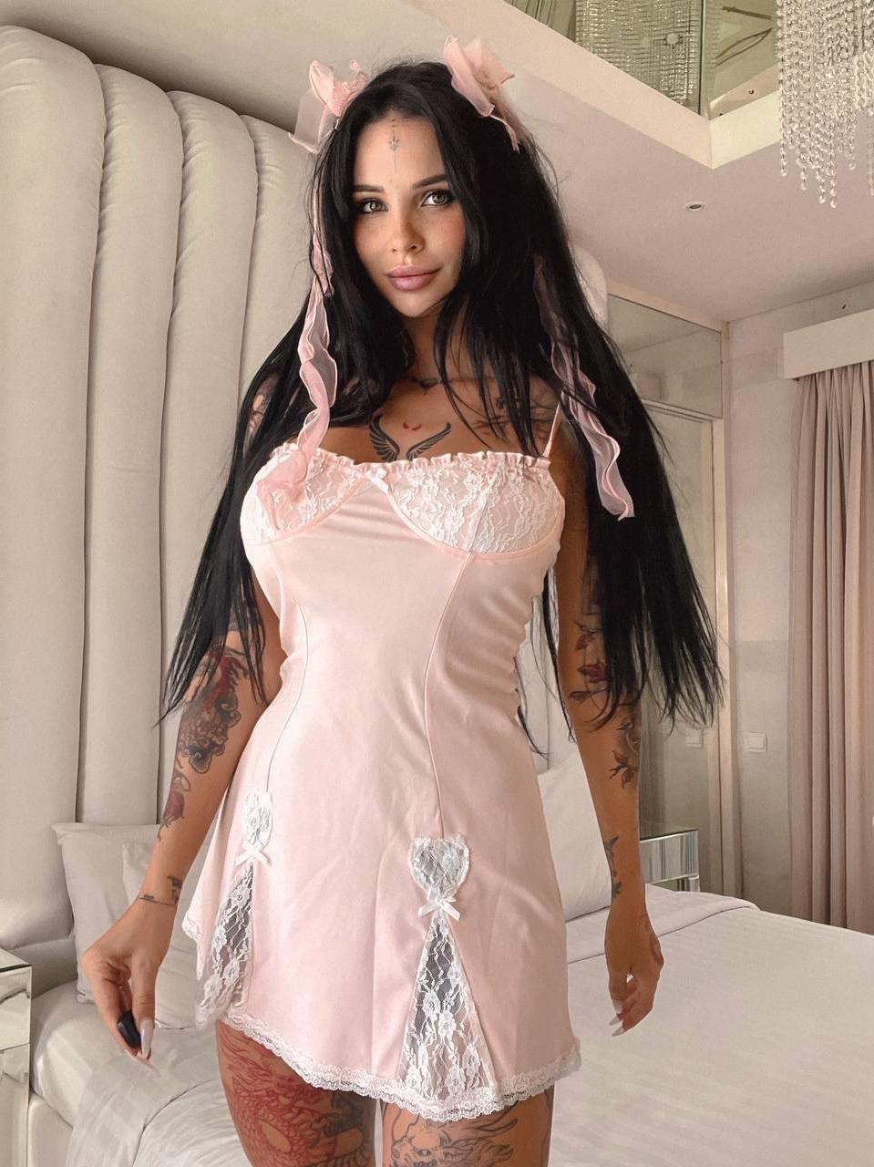 13P Une brune tatouée montre ses gros seins et son superbe cul sur son lit.