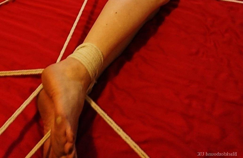 16P Une fille blanche à collier est attachée à un lit en lingerie rouge et une cagoule en latex