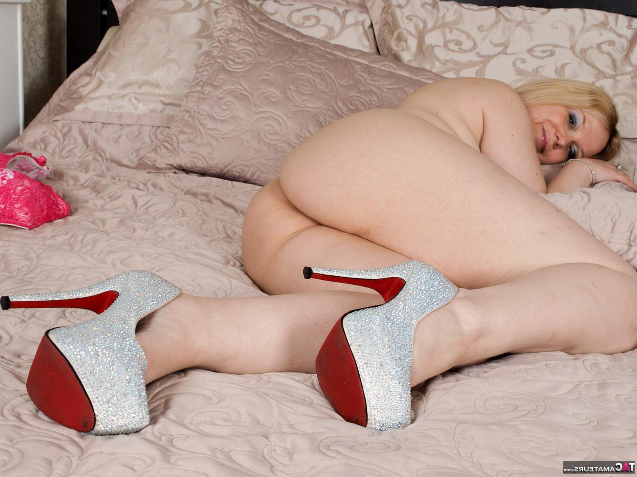 16P La gruesa rubia británica Sindy Bust se desnuda en la cama con zapatos de tacón alto